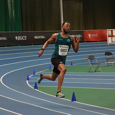 An athlete sprinting on an indoor track at the BUCS Indoor Championship