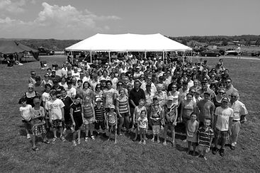 A faded image in the background of staff and their families at company celebration.