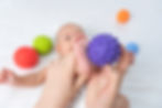 mom-massage-baby-s-feet-with-purple-rubber-ball-baby-massage-selective-focus.jpg