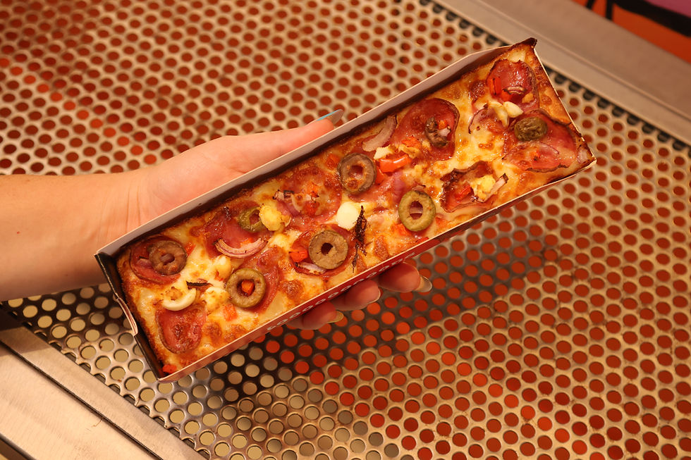 Jovens consumindo pizza King Pizza Looong em ambiente urbano