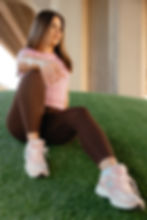 Woman in athletic wear relaxing on turf for wellness fitness
