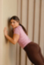Woman doing wall push-up, wellness fitness
