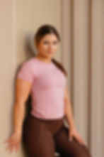 Woman in pink top, brown leggings for wellness fitness