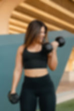 Smiling woman lifting dumbbells for wellness fitness