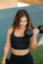 Smiling woman lifting dumbbell, wellness fitness