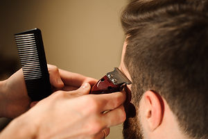 Master cuts hair and beard of men in the