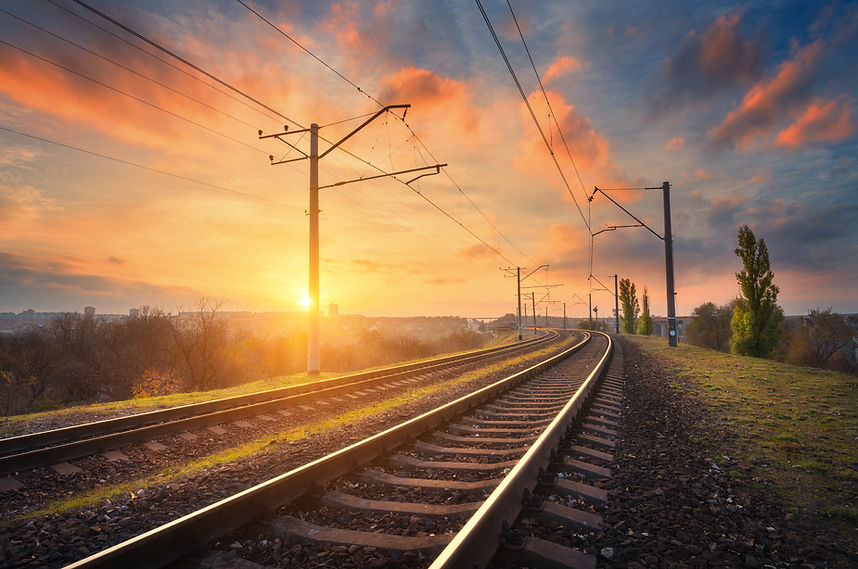 Railway station against beautiful sky at sunset. Industrial landscape with railroad, color