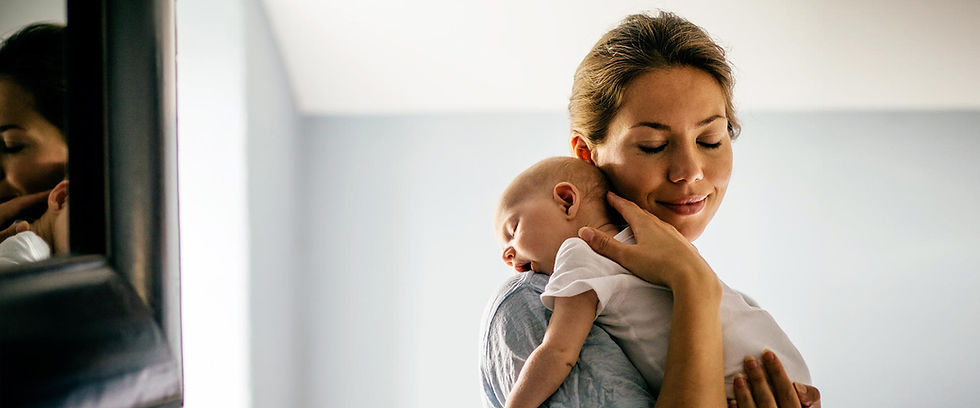 Woman cuddling baby with closed eyes