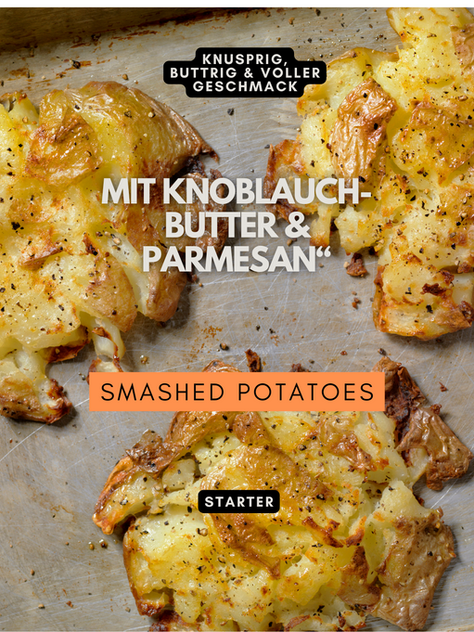 Perfekt knusprige Smashed Potatoes mit goldbrauner Kruste, getoppt mit geschmolzener Knoblauch-Butter & frisch geriebenem Parmesan, serviert auf einer rustikalen Holzplatte.