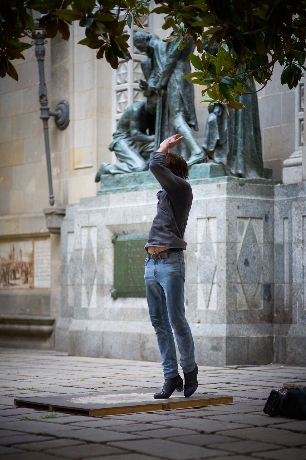 Thumbnail: Person jumping in front of a stone statue monument