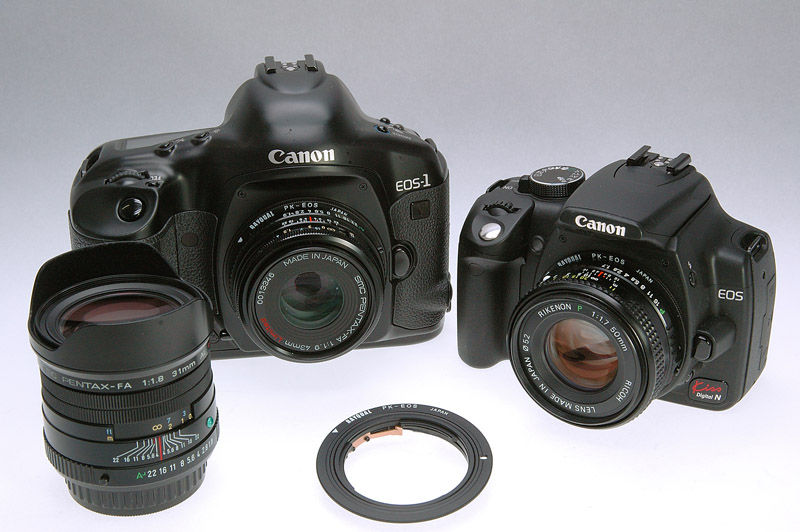 Thumbnail: Two black Canon cameras and lenses on a white surface