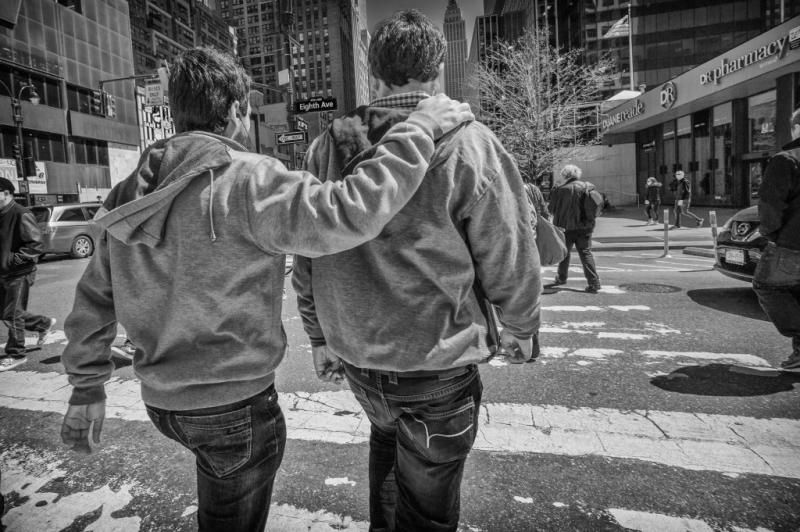Thumbnail: Street photo of two people walking in a city crosswalk.