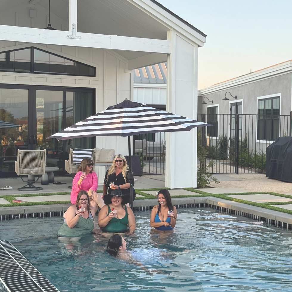 The ladies sipping drinks on the edge of the pool
