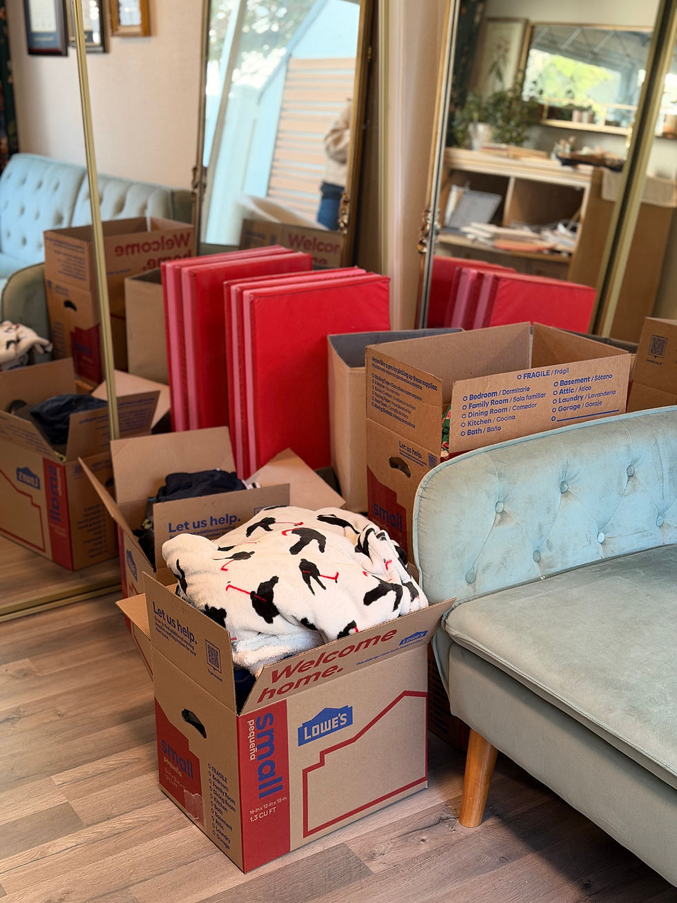 Boxes of kids clothes and a donation box in a home office during a decluttering reset