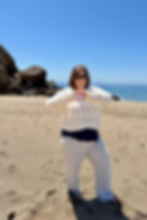 Erin holding hands in a heart shape on beach