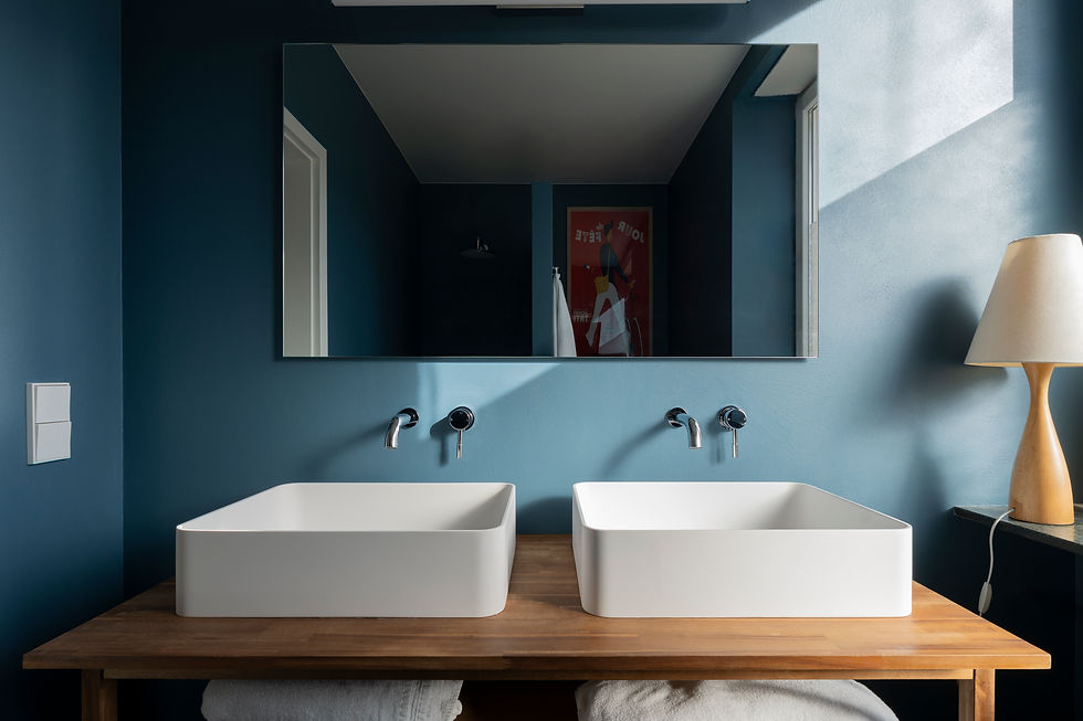Double vasque moderne sur comptoir en bois, mur bleu.