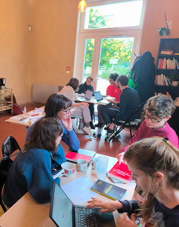 photo de plusieurs tables avec des personnes qui travaillent et discutent