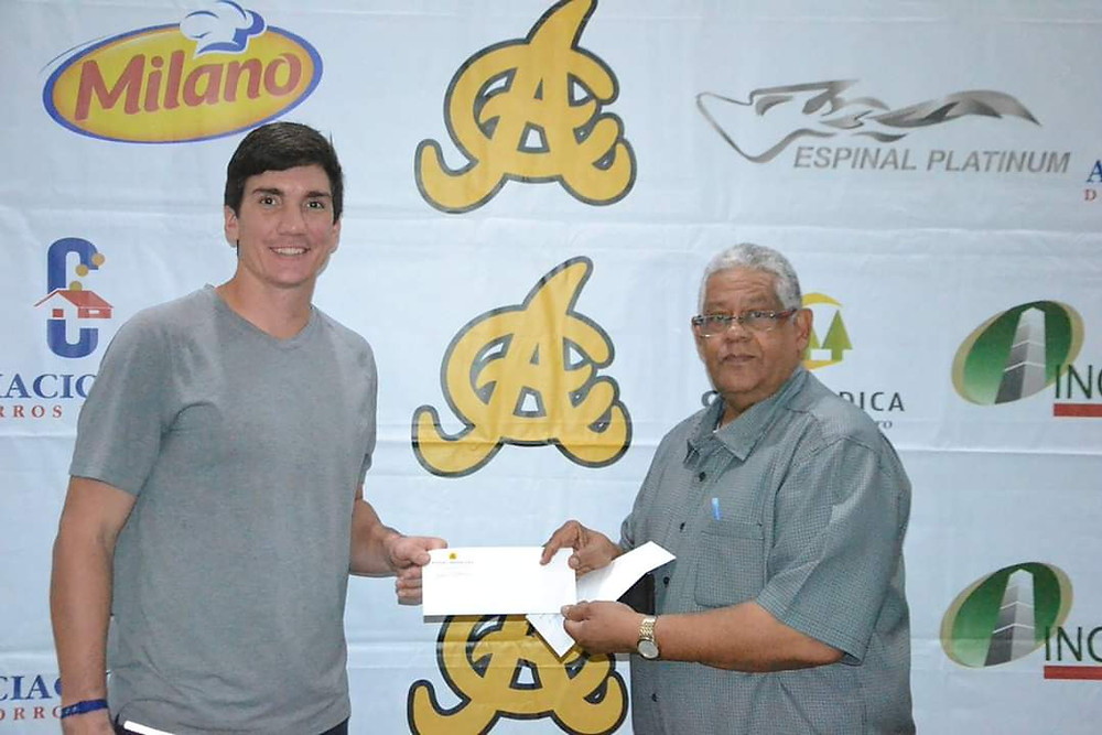 Jordan Patterson recibe de Rafael Pappy Perez su premio .