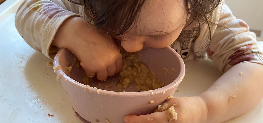 Baby, 6 Monate, beim genüsslichen essen mit seinen Händen