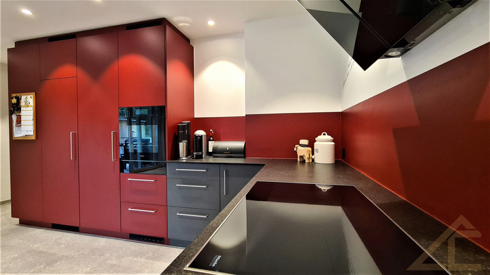 LC Küchen, LC-Holzbau, Küchen, Küchenbau, Küchenplanung, individuelle Küche, Eigenproduktion, Küchenvisualisierung, Küchenrealisierung, Prättigau, Graubünden, Ostschweiz, Traumküche, Kunstharz matt, rote Küche, Steinabdeckung, Naturstein, Miele Küchengeräte, Wärmeschublade, Vakumierschublade