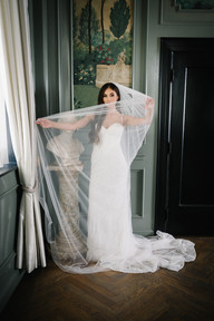 Bride in wedding dress standing in drawing room at The Mason Dallas during bridal portraits