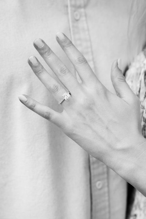 Black and white detail photo of engagement ring on hand.