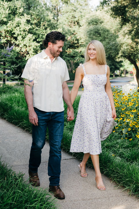 Engaged couple walking by garden flowers in Dallas.