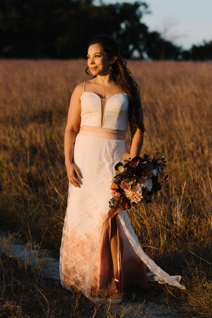Bride standing in tall grass with bouquet at Winfrey Point Dallas wedding.