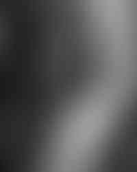 Black and white photo of bride standing by window during bridal portraits at The Mason Dallas