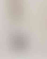 Elegant engagement photo with couple kissing by tall stone columns, romantic and modern Dallas engagement photography with architectural details.