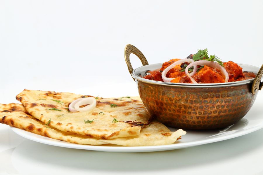 "Chicken Jhalfrezi served in a coper balti dish with naan bread"
