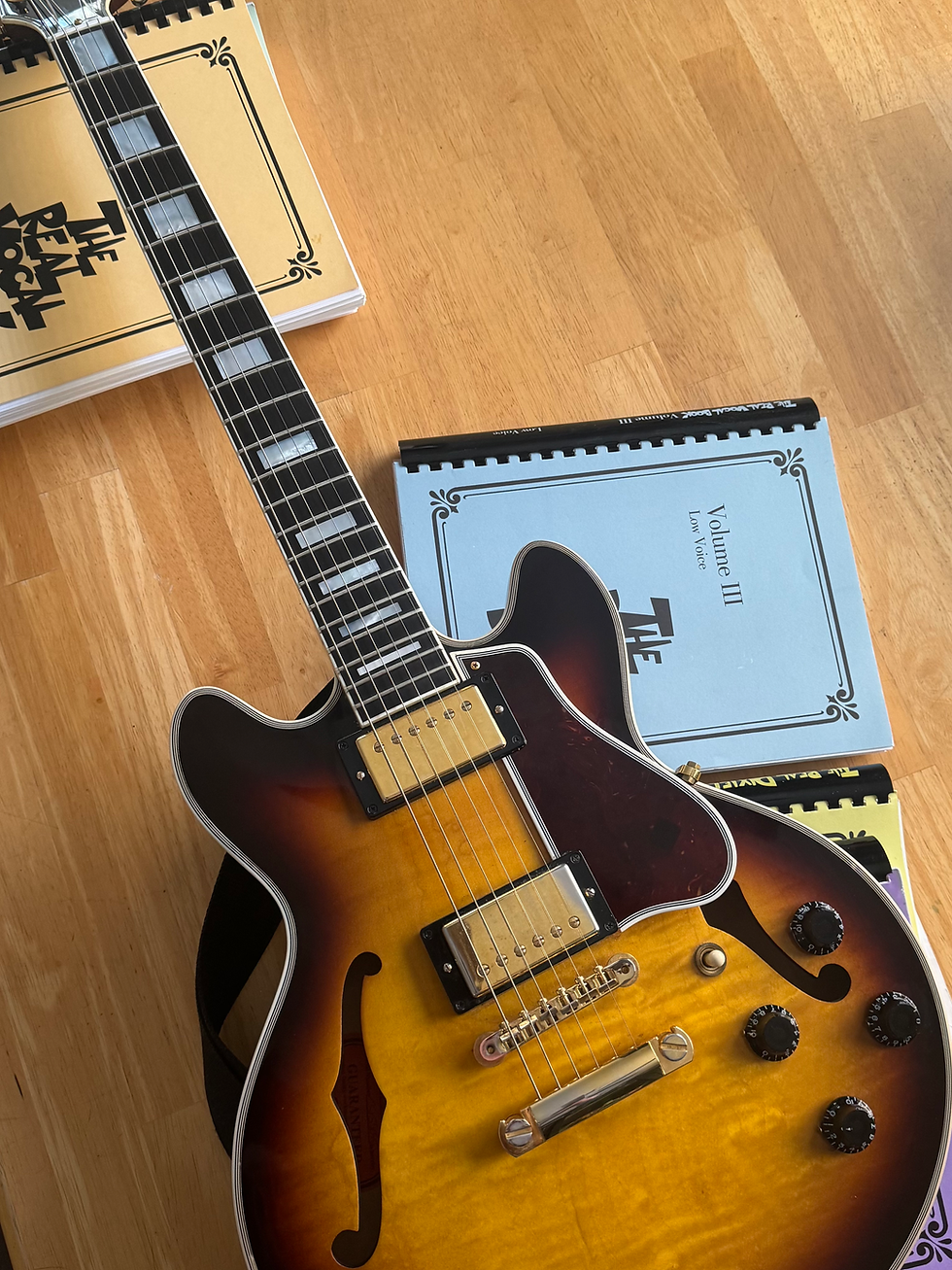 Semi-hollow body guitar with music books.