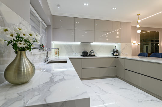 Mid grey handleless kitchen in a modern style and marble look stone benchtops