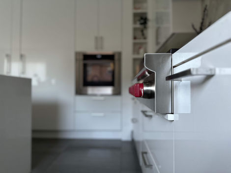 Thornhill kitchen restoration by StrongRise Builders featuring a precision-integrated Wolf high-output range with iconic red control hardware and a wall-mounted dual-convection oven system.