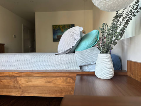 Bedroom with a modern custom-built bed from natural wood, bookmatched design, high-end woodwork, and custom woodwork throughout in York Region, including Thornhill and Vaughan.