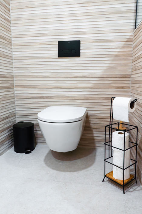 Wall-mounted floating toilet with matte black accessories and wood-look wall tile in Vaughan.