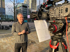 a news presenter stood in front of a camera