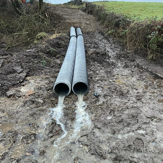 The first section of new drainage pipes replacing a collapsed culvert