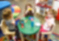Toddlers Playing with a Dollhouse