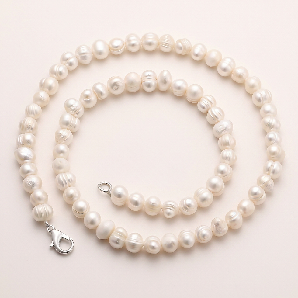 Elara Pearl Necklace coiled on a light surface