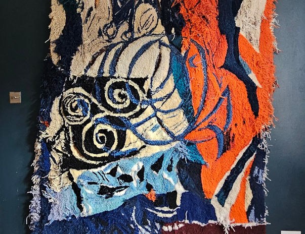 Tamessa Capall Mara Wall Hanging by Ryka Design shown in full front view on deep teal wall displaying complete composition with navy and cream spiral and figurative forms on left contrasting with vivid burnt orange on right