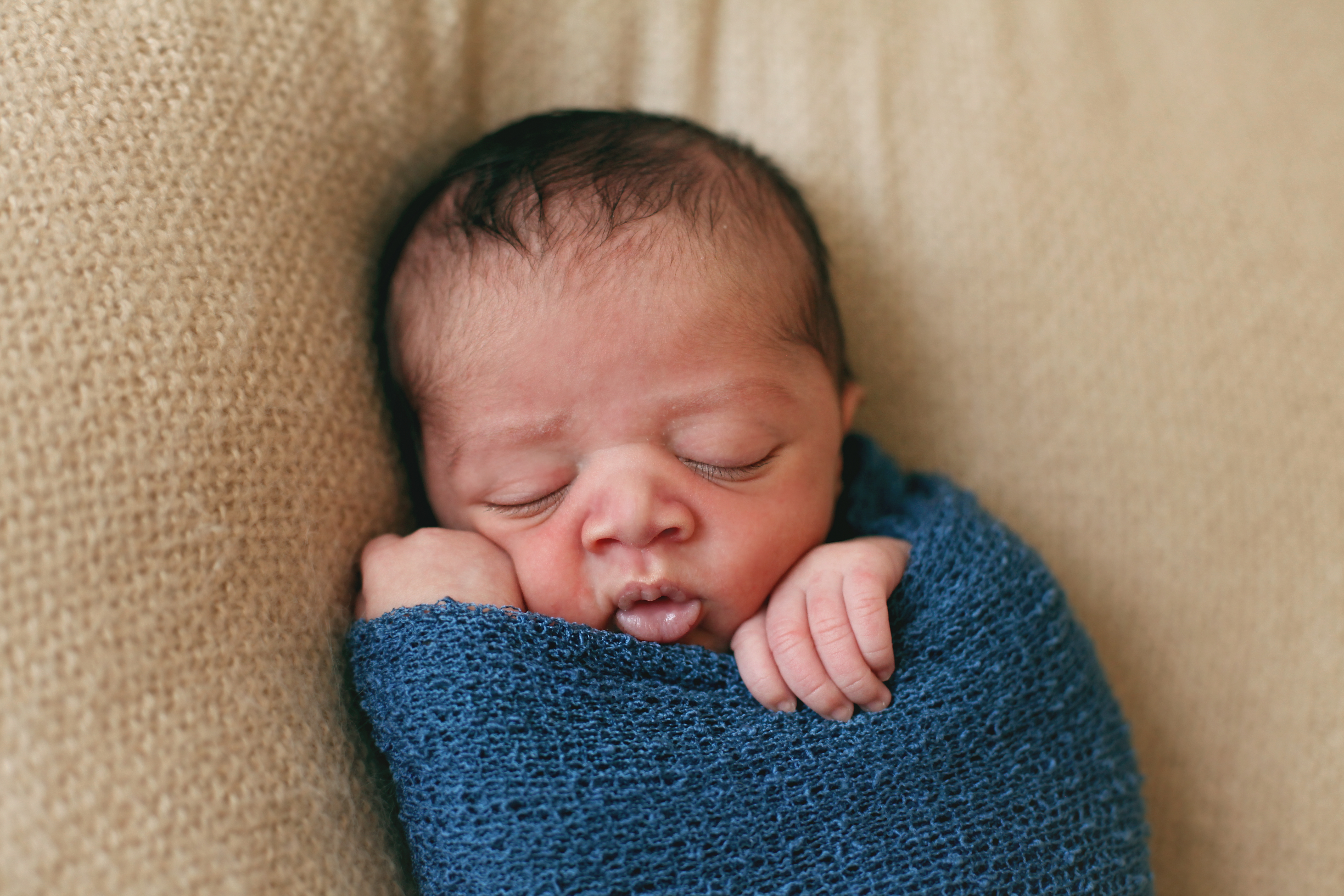 baby in blue swaddle