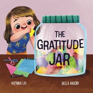 A little girl putting a note inside a jar that reads 'Gratitude Jar.'