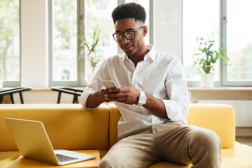 smiling-young-african-man-sitting-coworking-chatting-by-phone.jpg