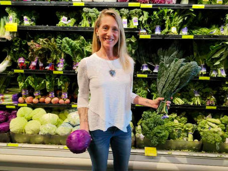 Karen Di Gloria holding fresh, whole, organic vegetables from Whole Foods