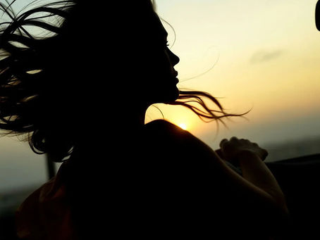 Shadow woman driving away while looking at her past in rear view mirror