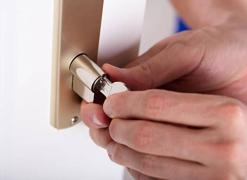 Hands installing a lock cylinder into a door handle plate