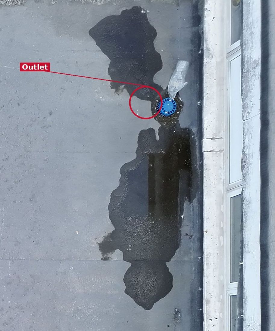 Annotated drone photo of a roof outlet with water ponding either side