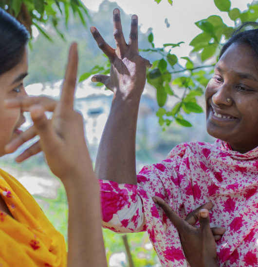 Detail from report cover. Two Nepalese women use sign language to communicate