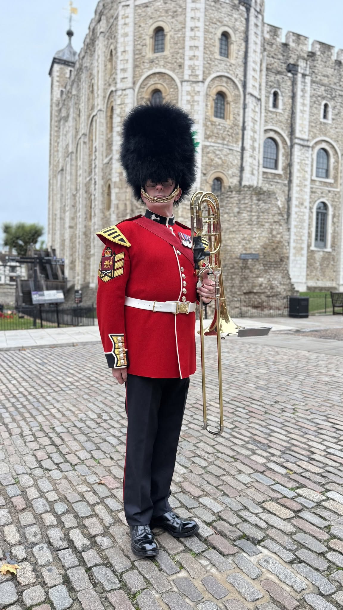 David Lockwood in Welsh Guards ceremonial uniform with bass trombone outside the Tower of London